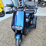 Blue scooter with a visible brand logo on a gravel surface