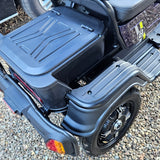 Black storage box attached to a vehicle on a gravel surface