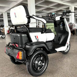 White and black three-wheeled vehicle with a large storage box in a showroom.