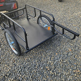 Black metal cargo trailer on a gravel surface