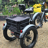 Gray cargo electric quad bike with a black basket in a garden setting