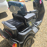 Black mobility scooter on a gravel surface