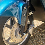 Close-up of a motorcycle wheel with blue fender on a gravel surface