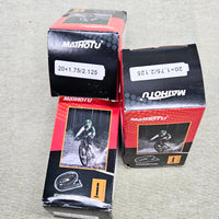 Three Mathotu bicycle tube boxes on a gray surface