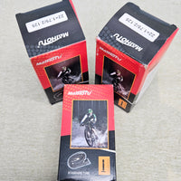 Three packages of Matoutou bicycle tubes on a gray surface
