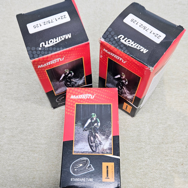 Three packages of Matoutou bicycle tubes on a gray surface