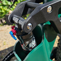 Close-up of a green scooter with a black suspension fork and DRT branding.