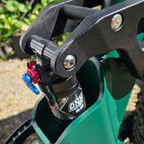 Close-up of a green scooter with a black suspension fork and DRT branding.