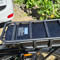 Black bike rack attached to a vehicle with a blurred background