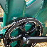 Close-up of a bicycle chain and gear system on a teal bike frame.
