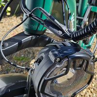Close-up of a motorcycle headlight and handlebar with a blurred background